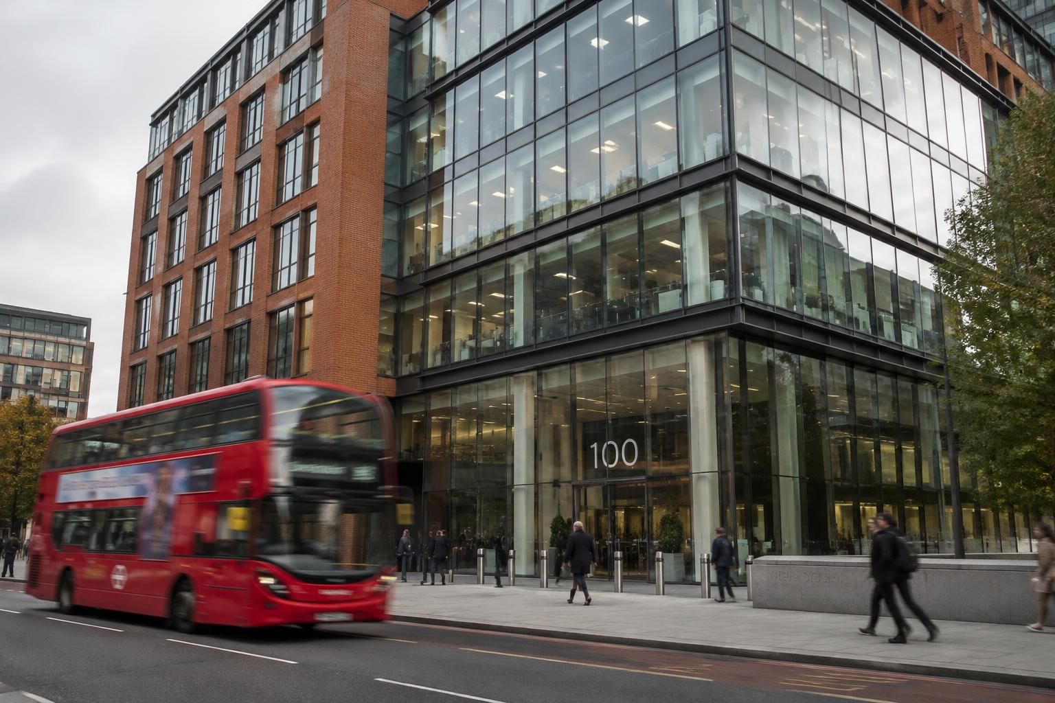 A modern city office building with a red bus passing on the street